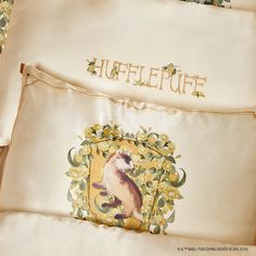 two pillows with embroidered animals on them and the words'hufflepuff '