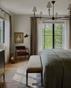 a bedroom with a large bed and lots of windows