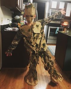 a young boy dressed as groote from the movie star wars standing in a kitchen