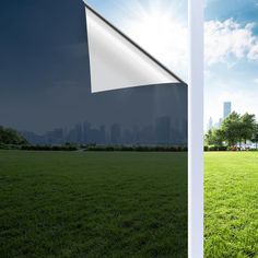 an open field with green grass and buildings in the background