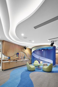 the interior of a modern office with curved walls and blue carpet