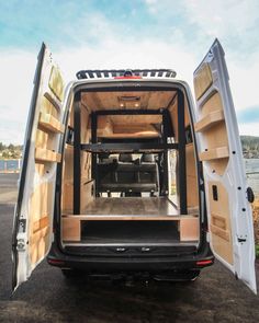 the back end of a white van with its doors open and it's cargo door opened