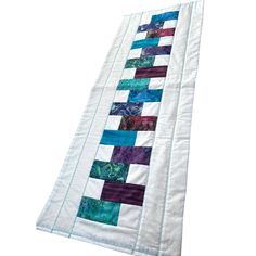 a quilted table runner with different colors and designs on the border, along with an applique pattern