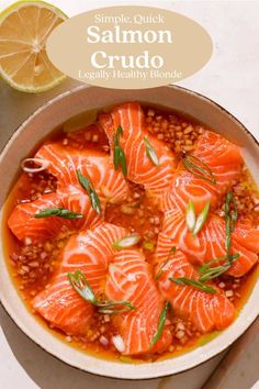 salmon and lentula soup in a bowl with garnish on the side next to a slice of lemon