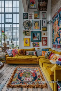 a living room filled with yellow couches and lots of pictures on the wall above them