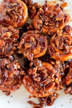 a white plate topped with lots of chocolate covered pretzel bites and caramel sauce