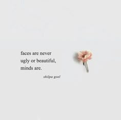 a pink flower sitting on top of a white surface next to a quote that says, faces are never ugly or beautiful minds are