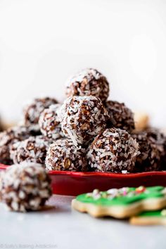 a plate full of chocolate nut balls next to cookies on a table with text overlay that reads, toffee noel nut balls hazel washington