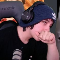 a young man wearing headphones while sitting in front of a computer