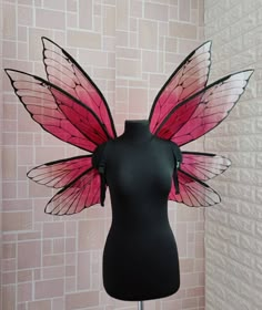 a mannequin wearing a pink and black butterfly wings costume