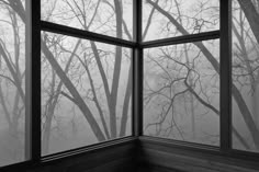 an open window with trees in the background and foggy sky outside, as seen from inside