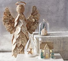 an angel figurine sitting on top of a table next to christmas decorations and ornaments