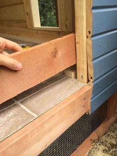 a person holding onto the side of a building with wood and wire on it's sides