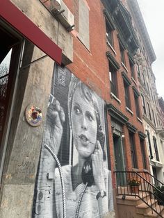 a mural on the side of a building in an alleyway with stairs leading up to it