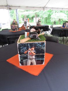 a baseball player is in the center of a box on top of an orange table cloth