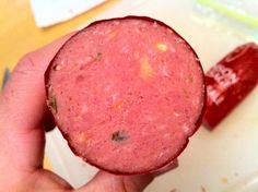 a close up of a person holding a piece of food in front of the camera