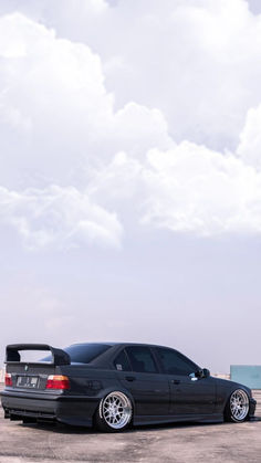 a black car parked on top of a parking lot