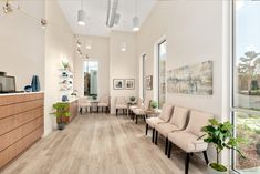 an empty waiting room with chairs and plants