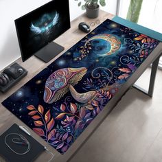 a computer desk with an artistic painting on it