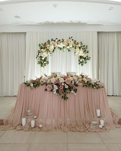 the table is set up with flowers and candles for an elegant wedding reception in pink