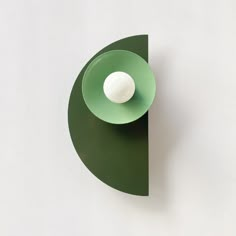 a green bowl with a white ball in it