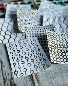 several different types of decorative paper sitting on top of a wooden table next to each other