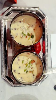 two silver trays filled with food on top of a table