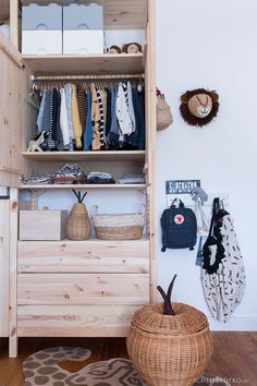 an organized closet with clothes and other items on the shelves, including a wicker basket