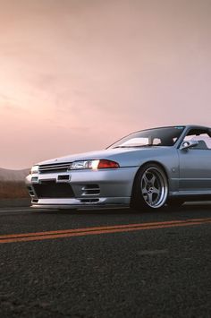 a silver sports car is parked on the side of the road