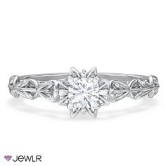 a white gold engagement ring with an intricate flower design on the band and center stone