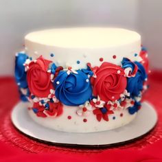 a white cake with red, white and blue frosting on it's side