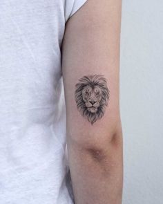 a small lion tattoo on the left arm