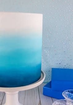 a blue and white ombrella cake sitting on top of a table next to a box