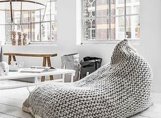 a bean bag chair sitting on top of a wooden floor next to a white table