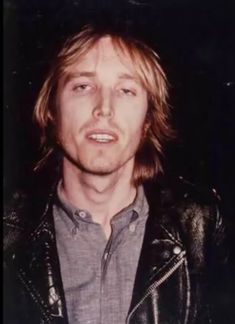 a man with long hair wearing a leather jacket