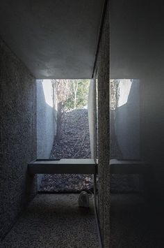 an empty room with concrete walls and stairs leading up to the bathroom area, where there is no one in it