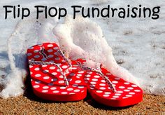 a pair of red flip flops sitting on top of a sandy beach