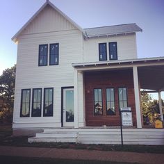 a large white house with three windows and a porch