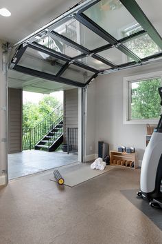 a garage with an exercise bike in the middle and stairs to the second floor on either side