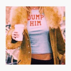 a woman holding a coffee cup and wearing a fur coat with dump him on it