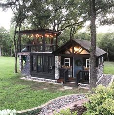 a small house with lights on the roof and windows in the front, surrounded by trees