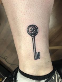 a small key tattoo on the ankle