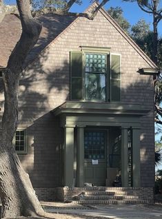 a house that has a tree in front of it and some windows on the side