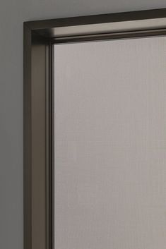 an open sliding glass door in the corner of a room with gray walls and flooring