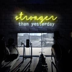 a neon sign that reads, strongen than yesterday