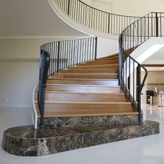 a spiral staircase with marble steps in a house