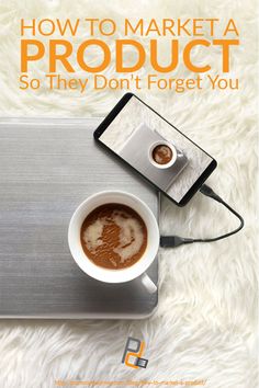 a cup of coffee sitting on top of a white rug next to a laptop computer