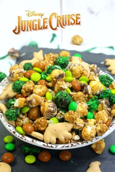 a bowl filled with some kind of food on top of a black table next to green and brown candies