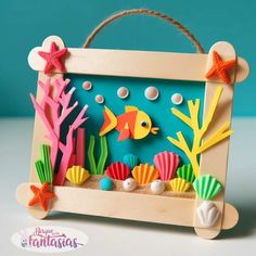 a wooden frame with sea animals and seashells on the bottom, in front of a blue background