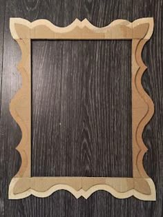 a wooden frame with scalloped edges on a wood surface, ready to be cut out